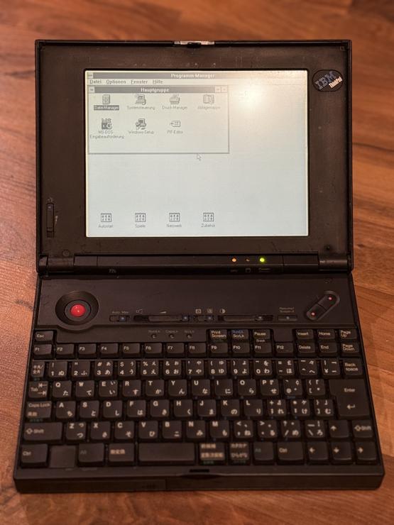 IBM ThinkPad 220 running on batteries, booted into Windows 3.11 program manager.